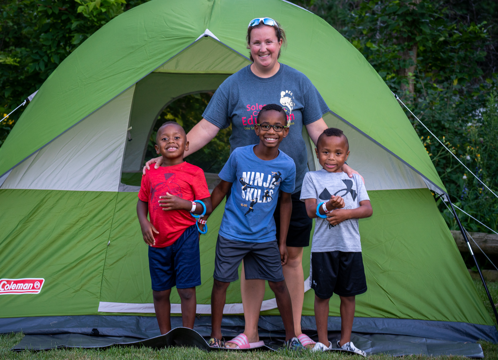 Campers by their tent at Snooze at the Zoo